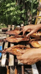 Traditional fish drying on a wooden rack in Matabu, Indonesia