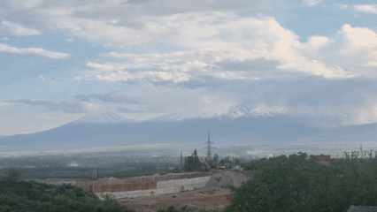 Construction site documented against snowy mountain backdrop