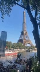 Seine river traffic and a riverside memorial near the Eiffel Tower