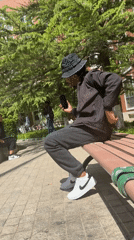Young man listens to music on park bench in Beijing