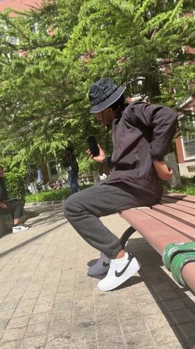 Young man listens to music on park bench in Beijing