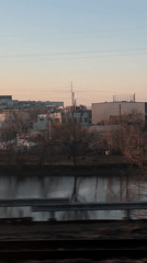 Train passenger views Philadelphia industrial riverfront through foggy windows