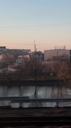 Train passenger views Philadelphia industrial riverfront through foggy windows