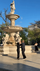 Couple tango dances near fountain in Budapest park