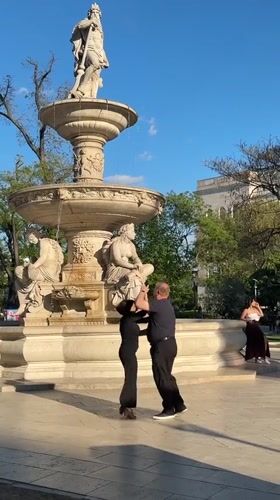 Couple tango dances near fountain in Budapest park