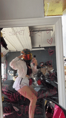 Woman on motorcycle captured in garage mirror reflection, Thailand