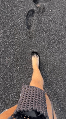Beach visitors enjoy black sand coastline in Indonesia