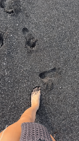 Beach visitors enjoy black sand coastline in Indonesia