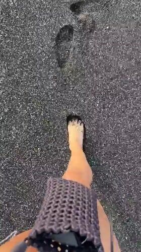 Beach visitors enjoy black sand coastline in Indonesia