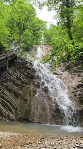Visitors document scenic waterfall near Podkhrebtovoe, Russia
