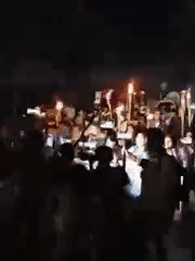 Torchlight procession with Bengali banners held in nighttime Dhaka