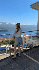 Woman enjoys scenic balcony moment in Budva, Montenegro