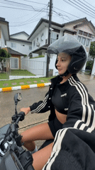 Woman rides scooter through wet Chalong streets after rainfall