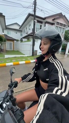 Woman rides scooter through wet Chalong streets after rainfall