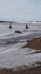 Winter vehicles navigate frozen waters near Russian Arctic settlement