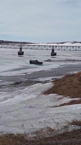 Winter vehicles navigate frozen waters near Russian Arctic settlement