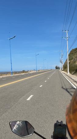 Morning motorcycle ride captured along coastal road in Vietnam