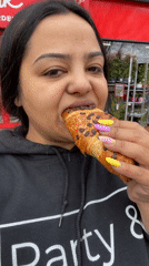 Woman enjoys chocolate croissant outdoors in Dronten