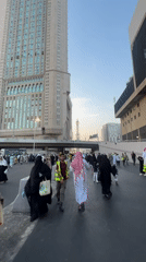 Crowds move through Mecca streets near a mosque minaret