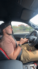 Driver checks phone while seated in Ford truck in Vietnam