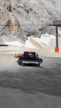 Snow groomers parked on an alpine slope near the Austrian-German border