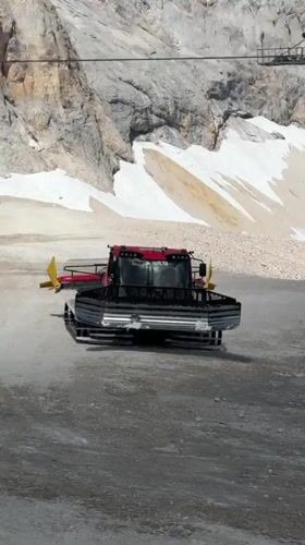 Snow groomers parked on an alpine slope near the Austrian-German border