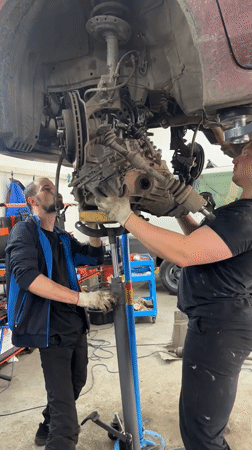 Mechanics install transmission at Blagoveshchensk auto repair shop