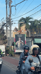 Restaurant advertisement spotted on Bali street with passing motorbikes