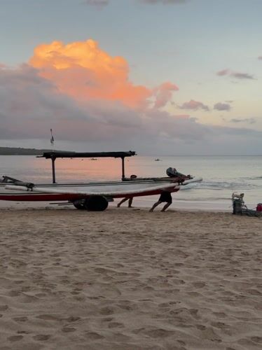 Tourist captures sunset moments with locals at Kuta Beach
