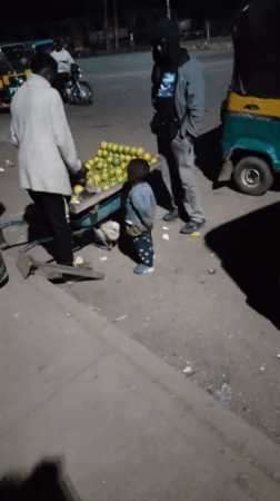 Night market activity in Bukuru, Nigeria — vendors, keke napeps, street food