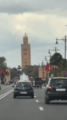 Traffic scene captured near historic minaret in Marrakesh