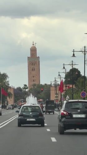 Traffic scene captured near historic minaret in Marrakesh