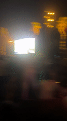Nighttime crowd event in Barcelona, colored smoke and big screen