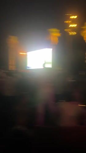 Nighttime crowd event in Barcelona, colored smoke and big screen
