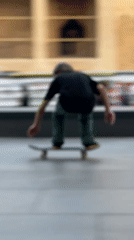 Grey-haired man skateboards in Barcelona plaza during golden hour