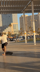 Skateboarder performs trick under covered walkway in Tel Aviv