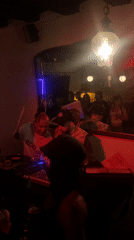 Two DJs performing at dimly lit club venue