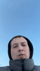 Couple takes winter selfies at frozen lake promenade