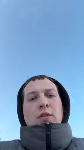Couple takes winter selfies at frozen lake promenade