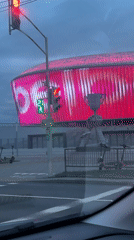 Illuminated stadium seen from car on rainy Minsk evening