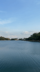 Woman points across lake toward hills in Tinaquillo, Venezuela