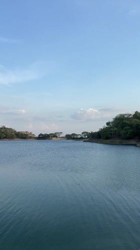 Woman points across lake toward hills in Tinaquillo, Venezuela
