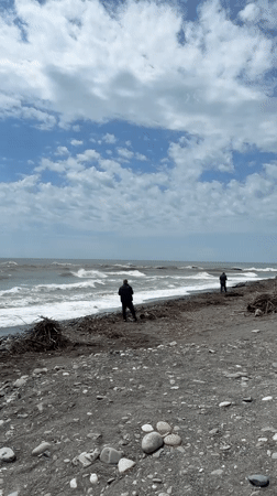 Two people fishing on rocky beach in Sirius, Russia