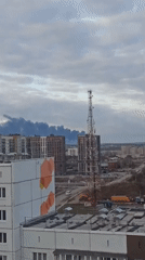 Cityscape with apartments and telecom tower documented under clouds