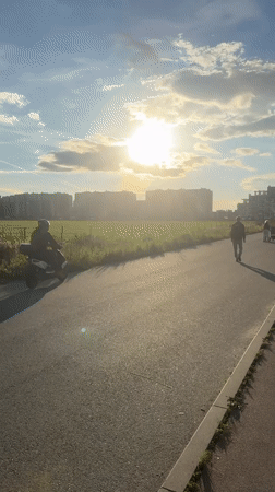 Afternoon in Murino: open fields, apartment blocks, and a passing helicopter