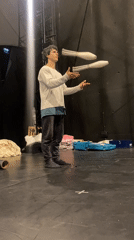 Street performer juggles clubs on marked stage in Paris