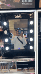 Young man takes selfies at cosmetics store mirror in Pampatar
