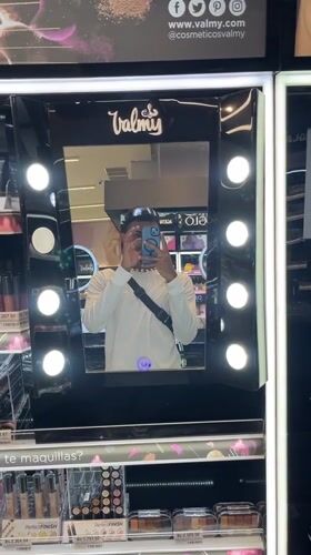Young man takes selfies at cosmetics store mirror in Pampatar