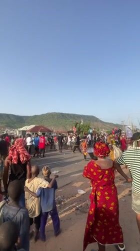 Crowd gathers in traditional dress on Lokoja street