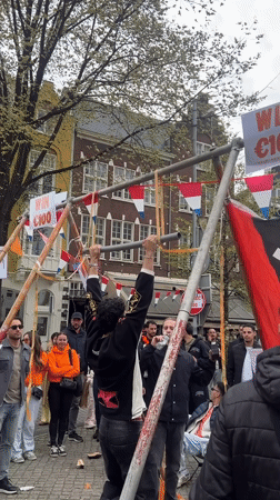 Young man performs pull-ups on outdoor bar in Amsterdam